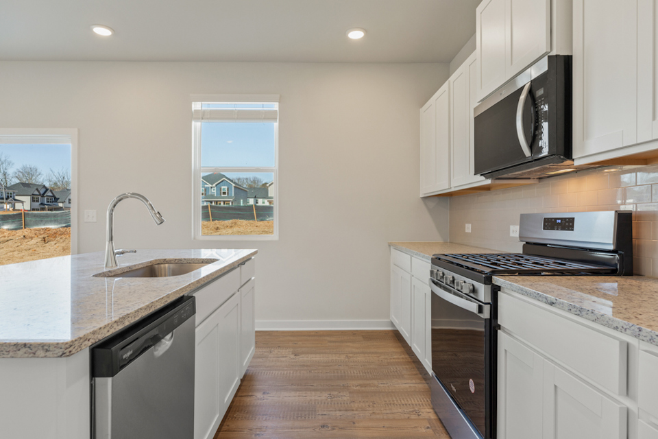 A kitchen with white cabinets.