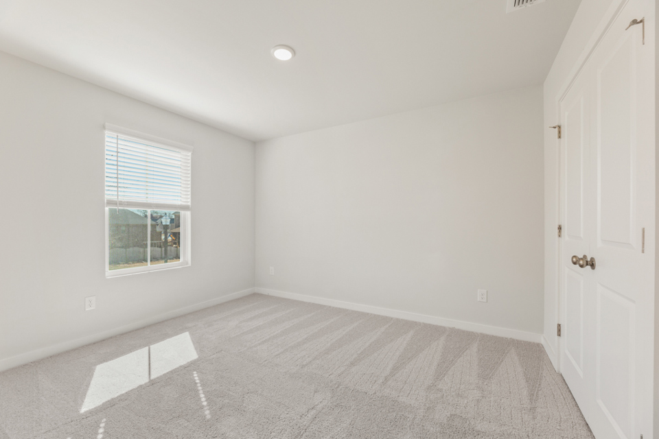 A room with white walls and a window.