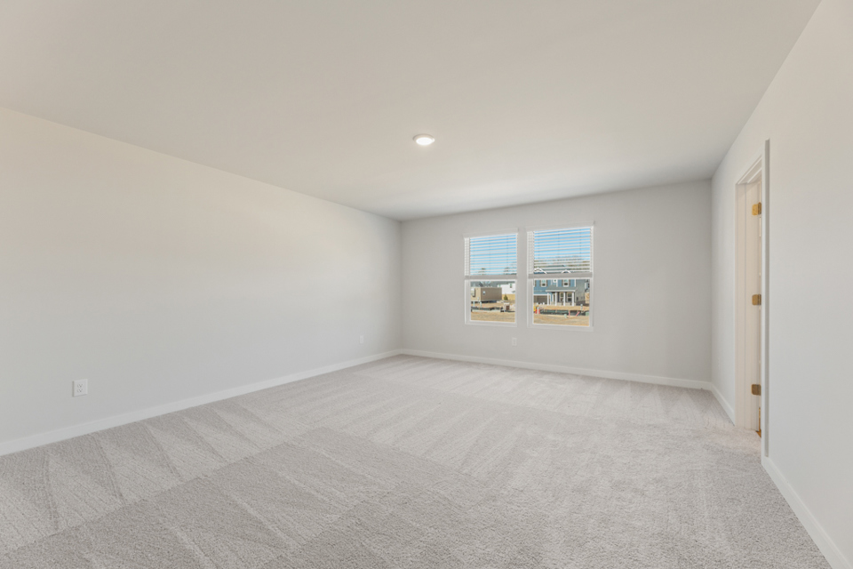 A room with a carpet and a window.