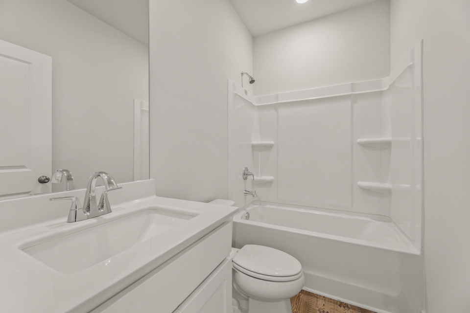 A bathroom with a tub sink and toilet.