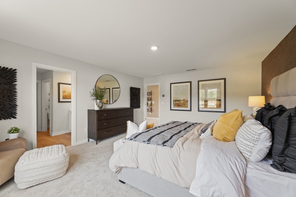 A bedroom with a bed and a mirror.