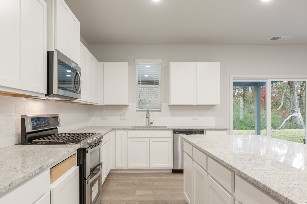 A kitchen with white cabinets.