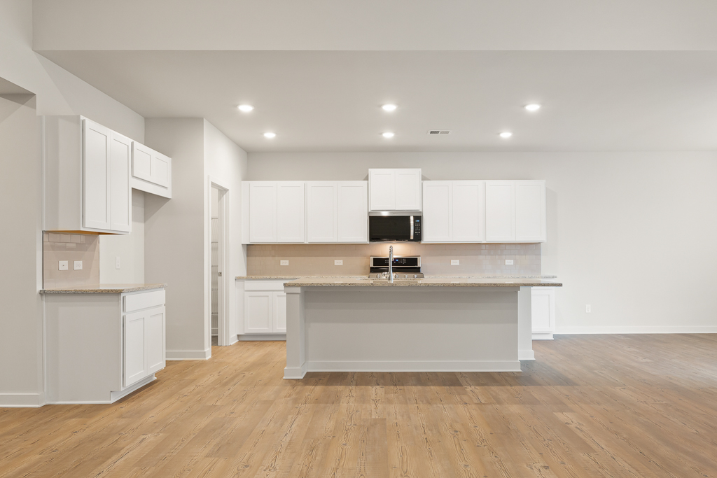 A kitchen with white cabinets.