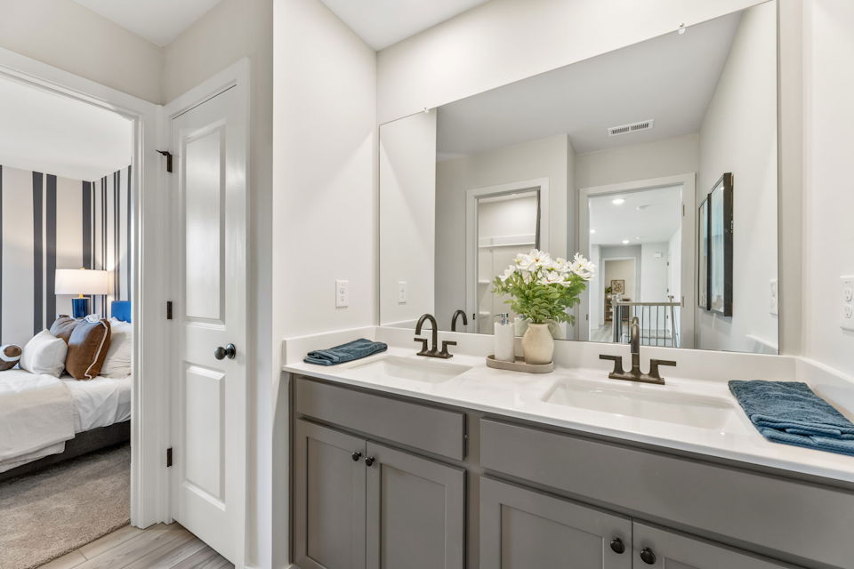 A bathroom with a sink and a bed.