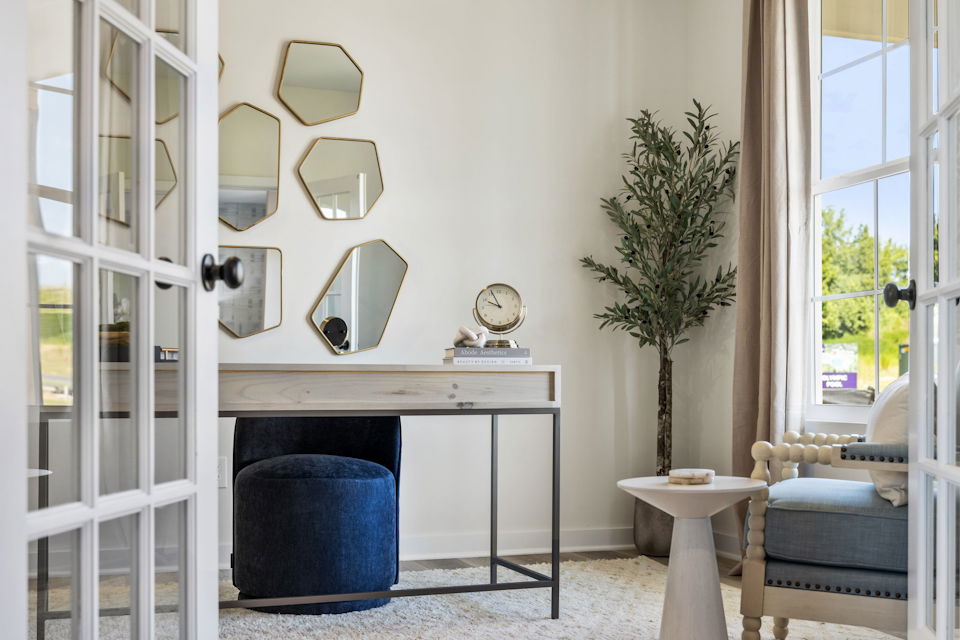 A room with a table and a chair and a mirror.