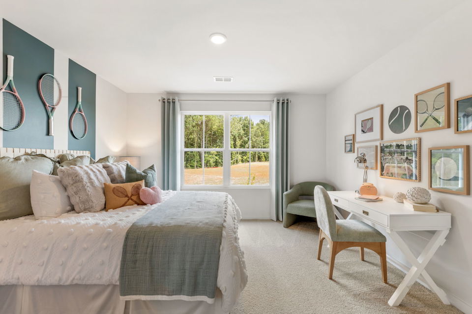 A bedroom with a bed and a table.