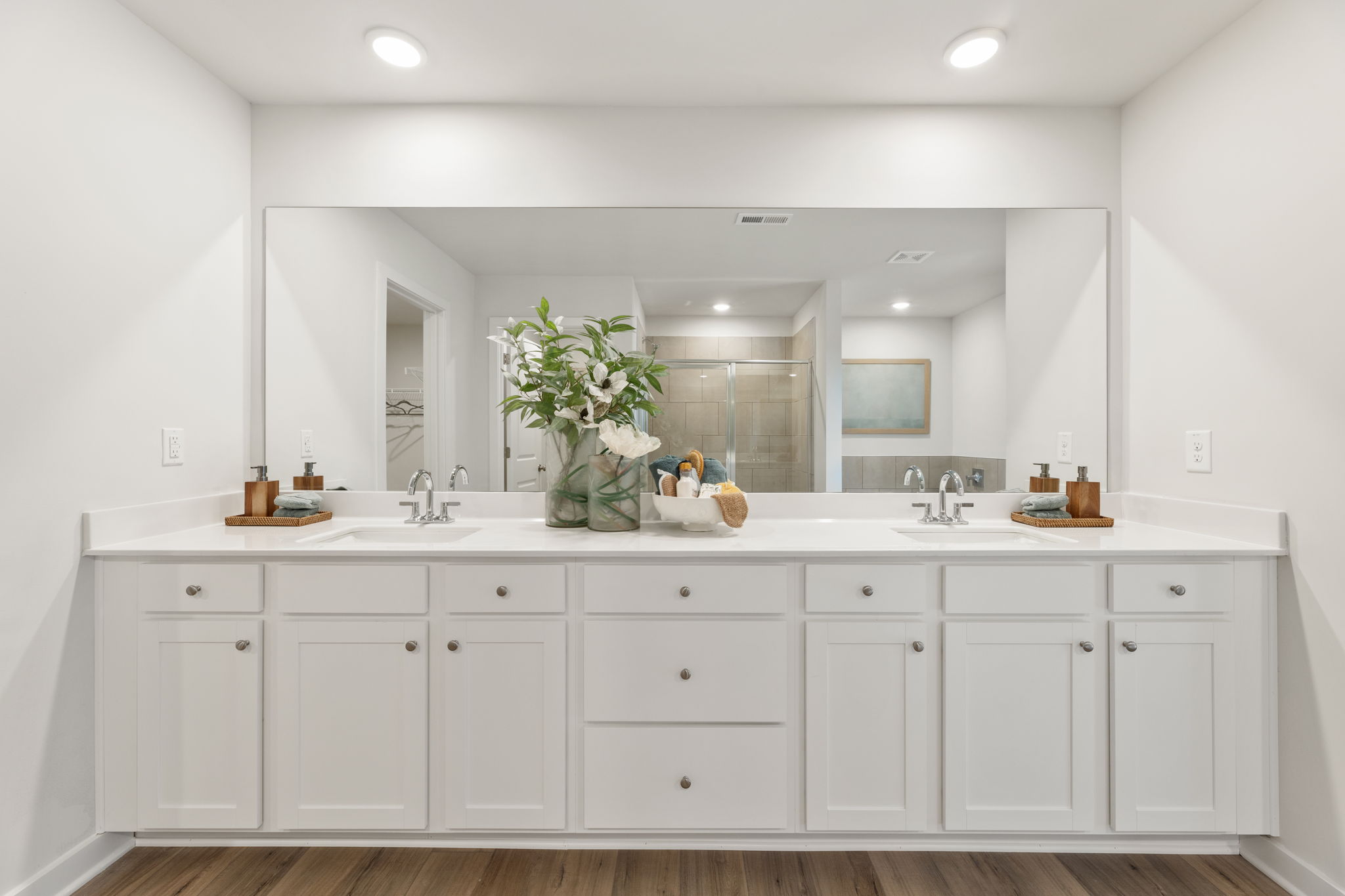 A bathroom with white cabinets.