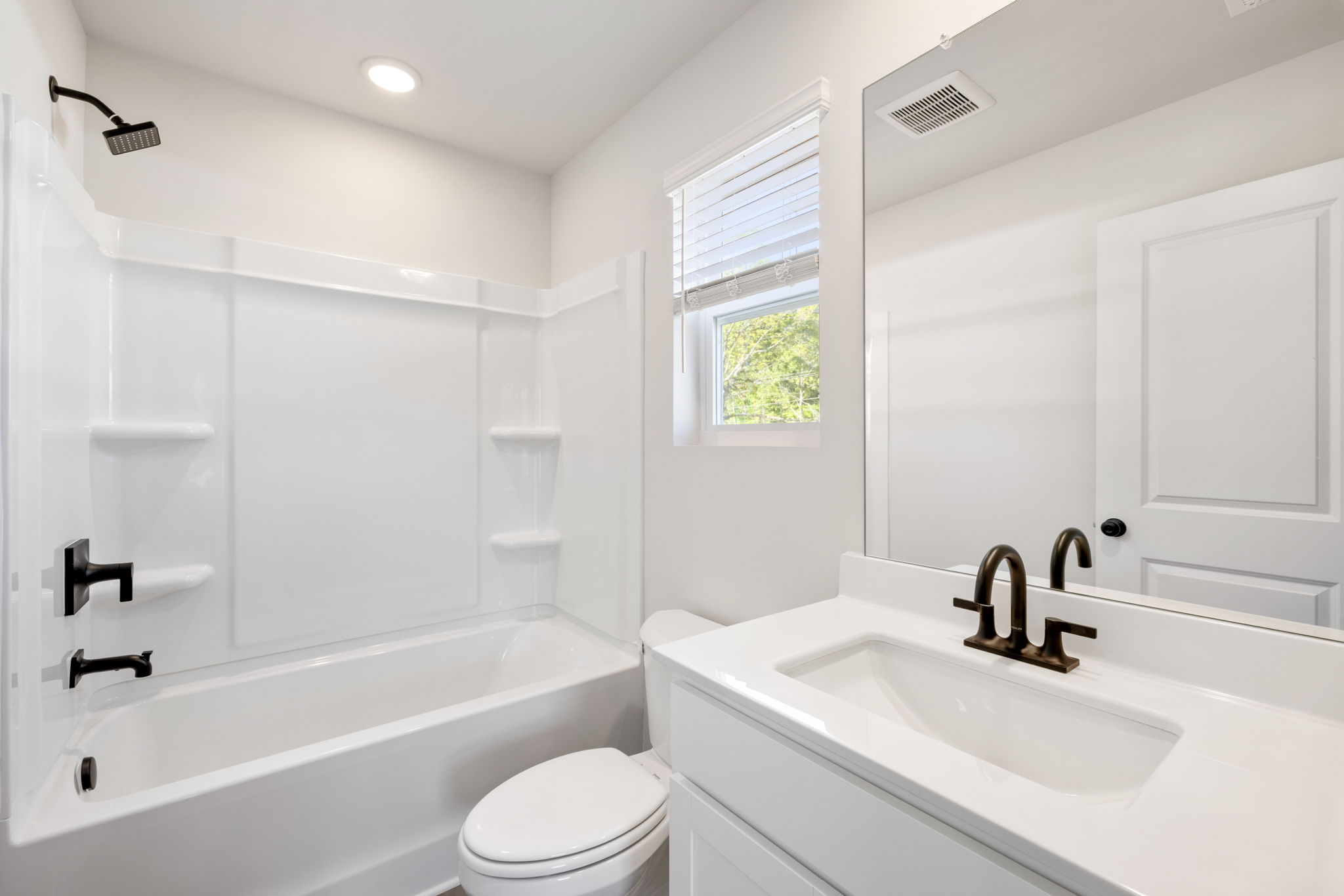 A bathroom with a tub sink and toilet.