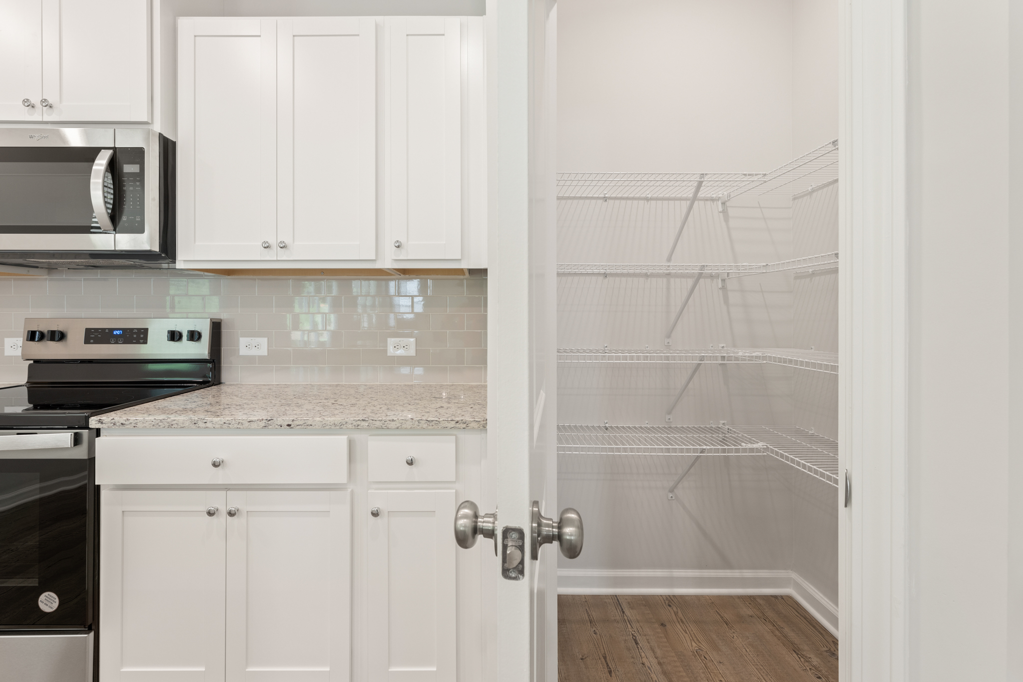A kitchen with white cabinets.