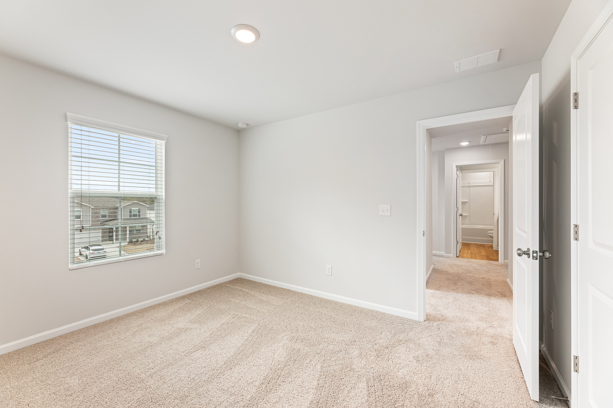 A room with a carpet and a door.