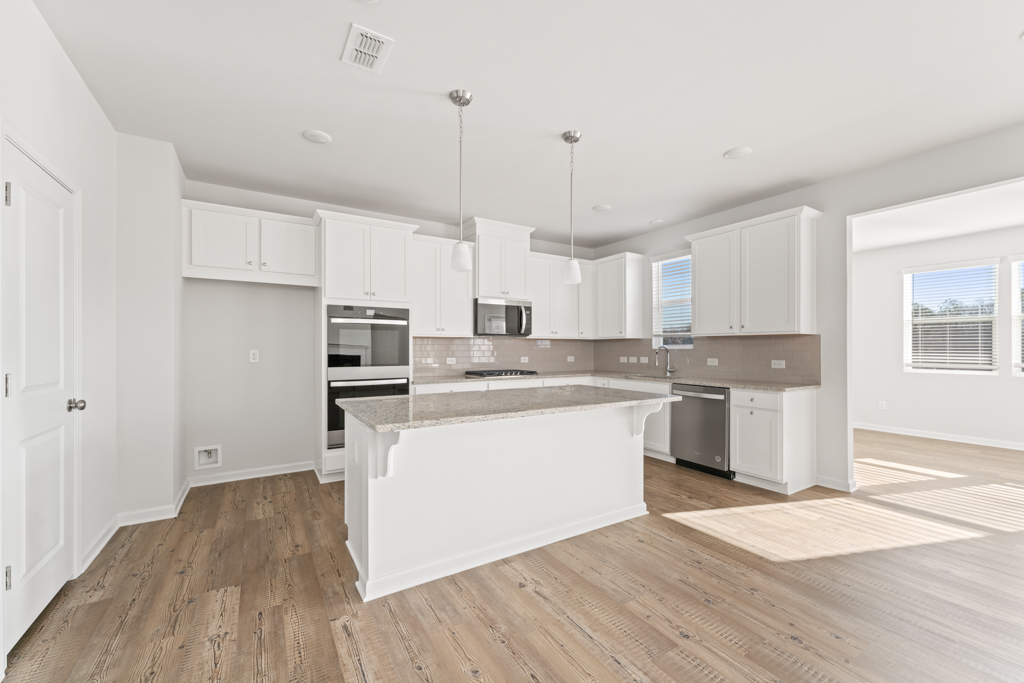 A kitchen with white cabinets.