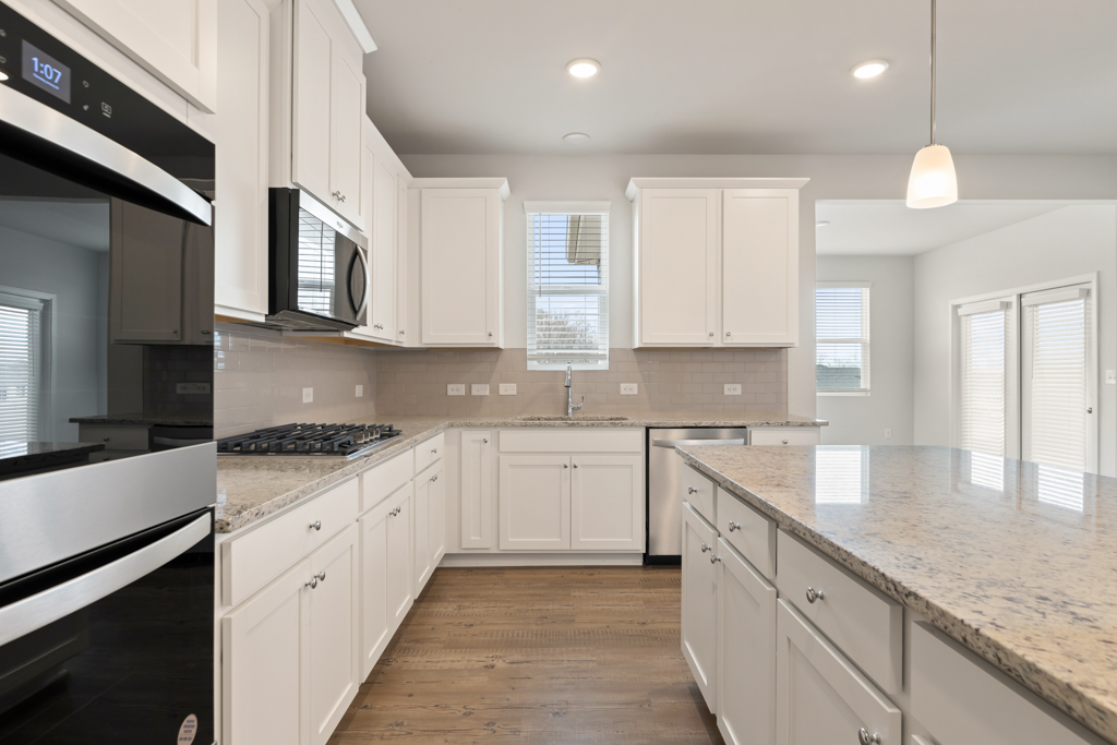 A kitchen with white cabinets.
