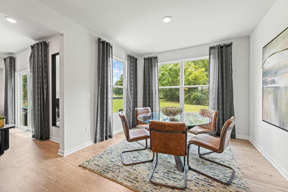 A room with a table chairs and a rug.