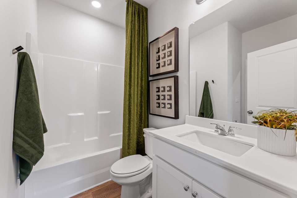 A bathroom with a green towel.