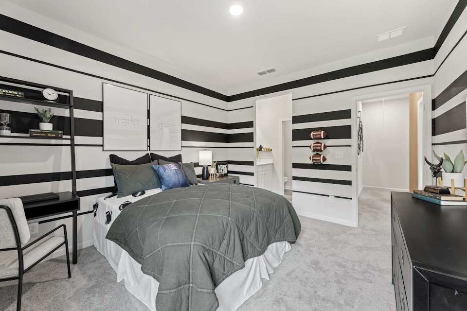 A bedroom with a bed and a desk.