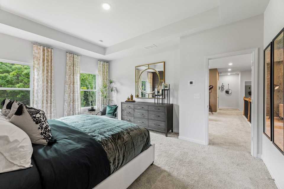 A bedroom with a large mirror.