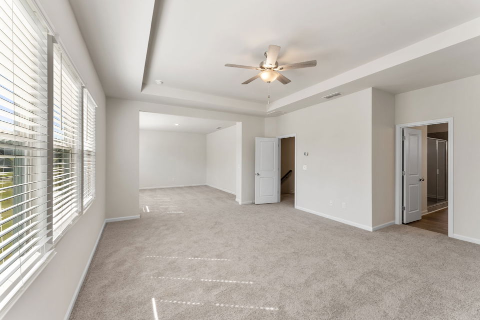 A room with a ceiling fan and a door.