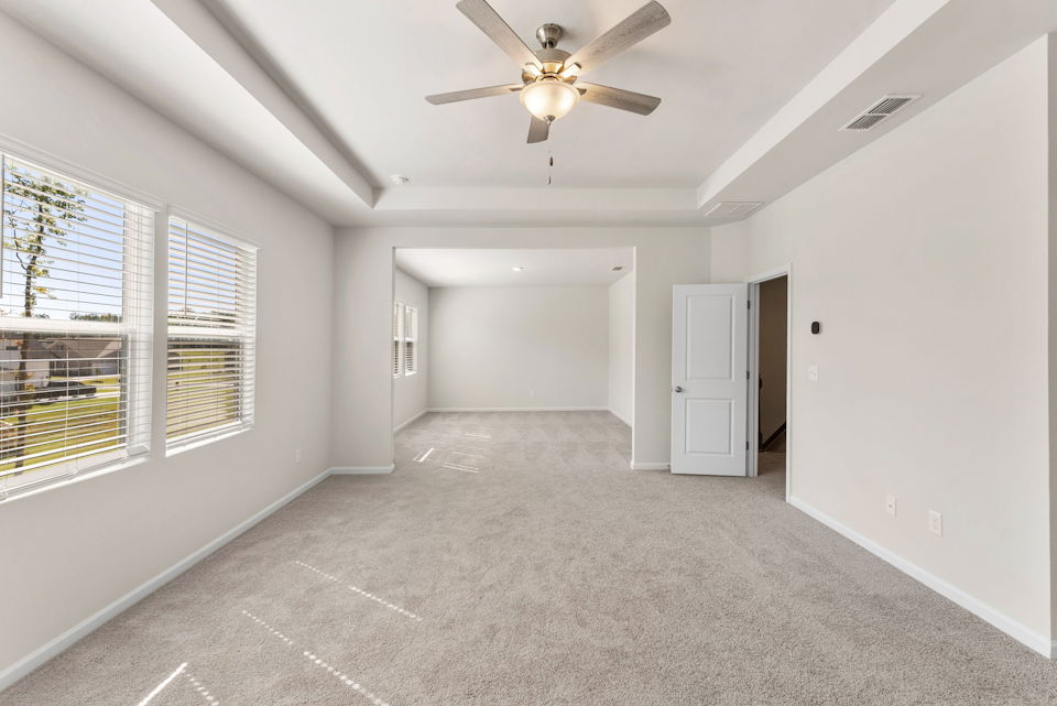 A room with a ceiling fan and a door.