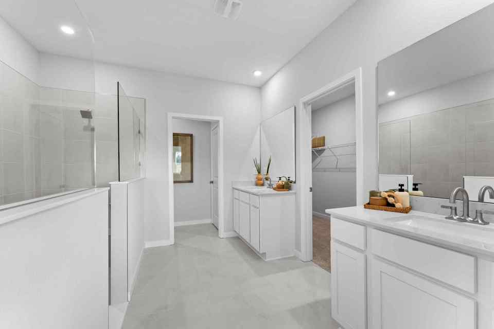 A bathroom with white cabinets.