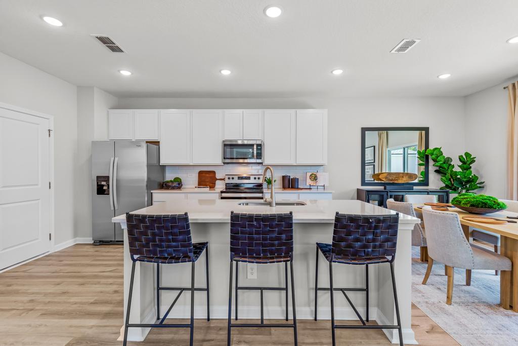 A kitchen with white cabinets.