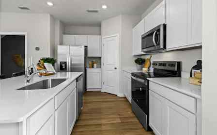 A kitchen with white cabinets.