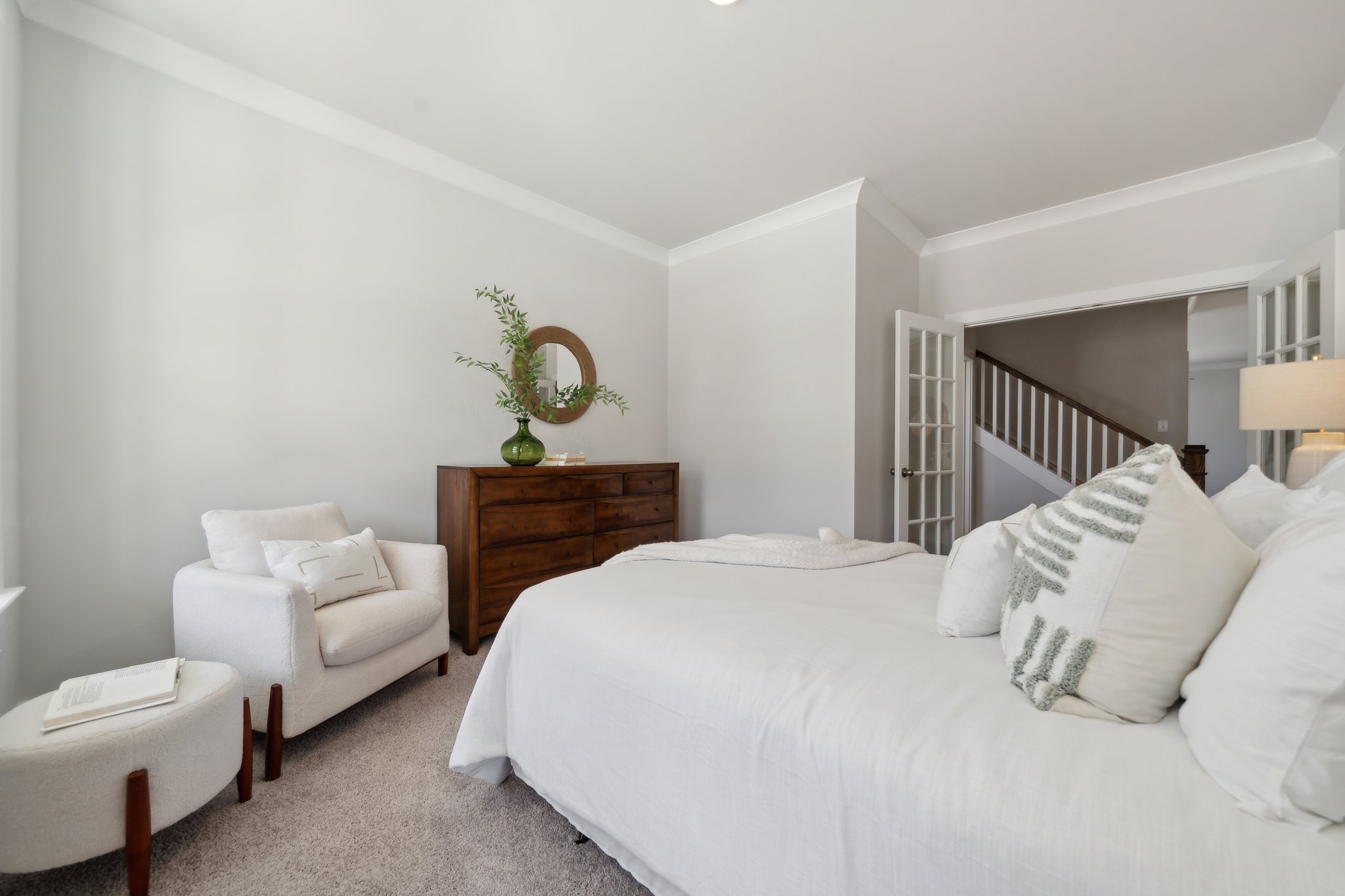 A bedroom with a bed and a chair.