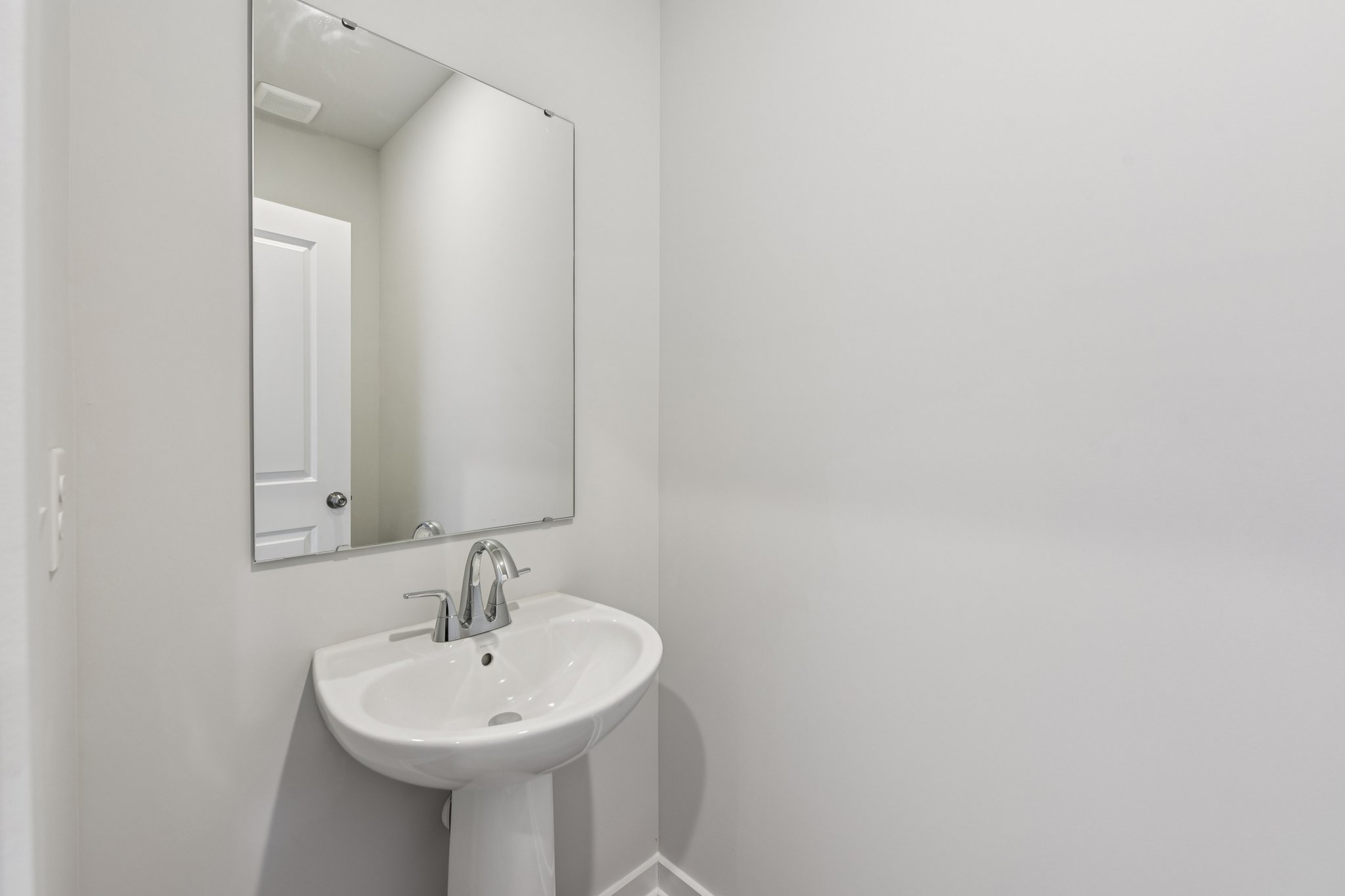 A bathroom with a mirror and sink.