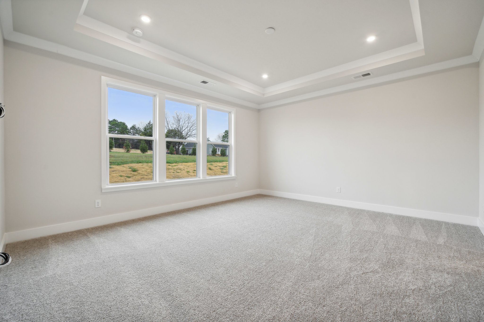 A room with a window and a carpet.