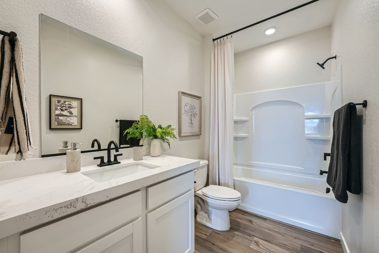 A bathroom with a tub sink and toilet.