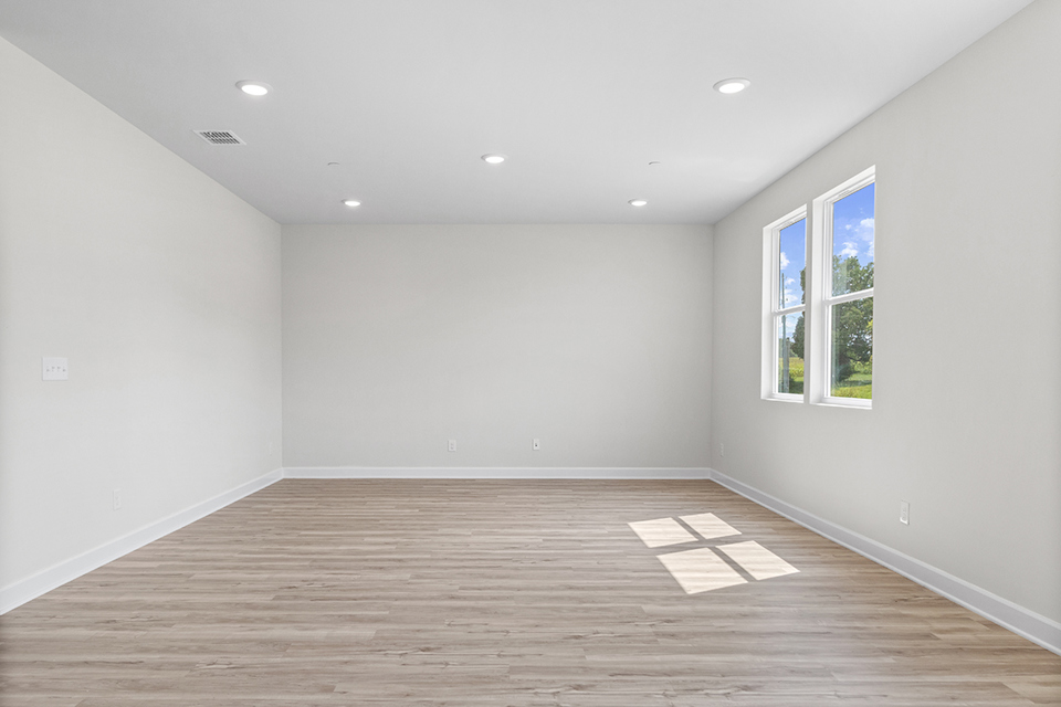 A room with a wood floor and windows.