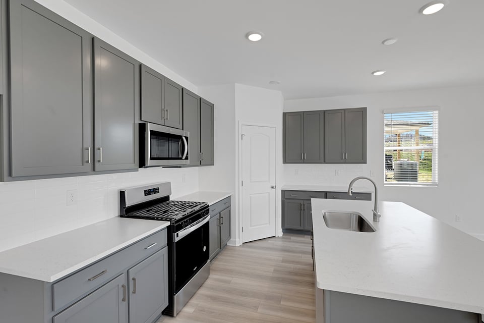 A kitchen with white cabinets.