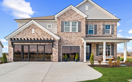 A brick building with a front yard.