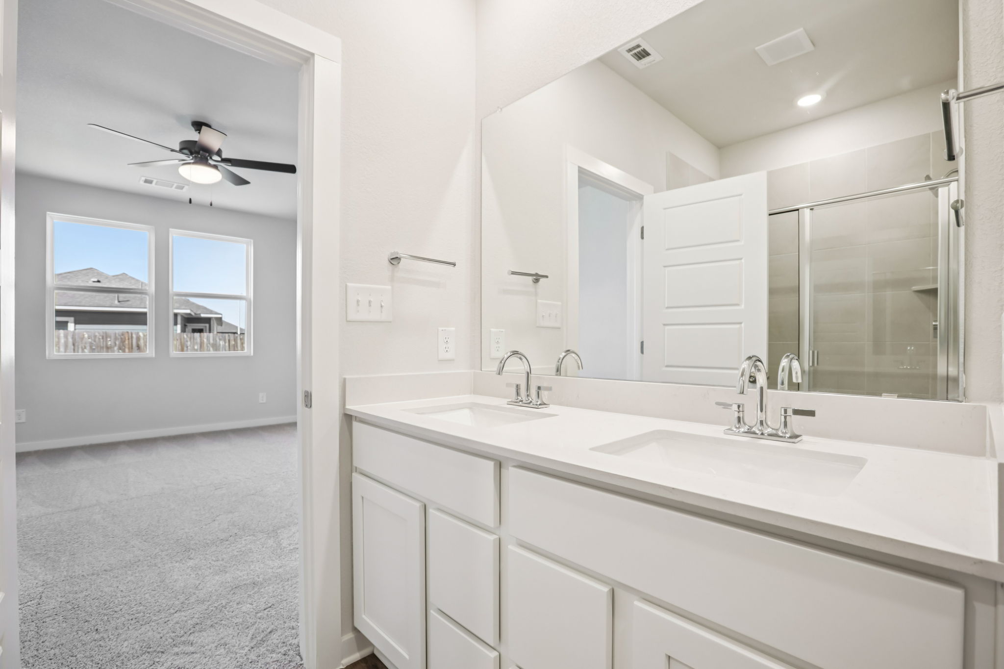 A bathroom with white cabinets.