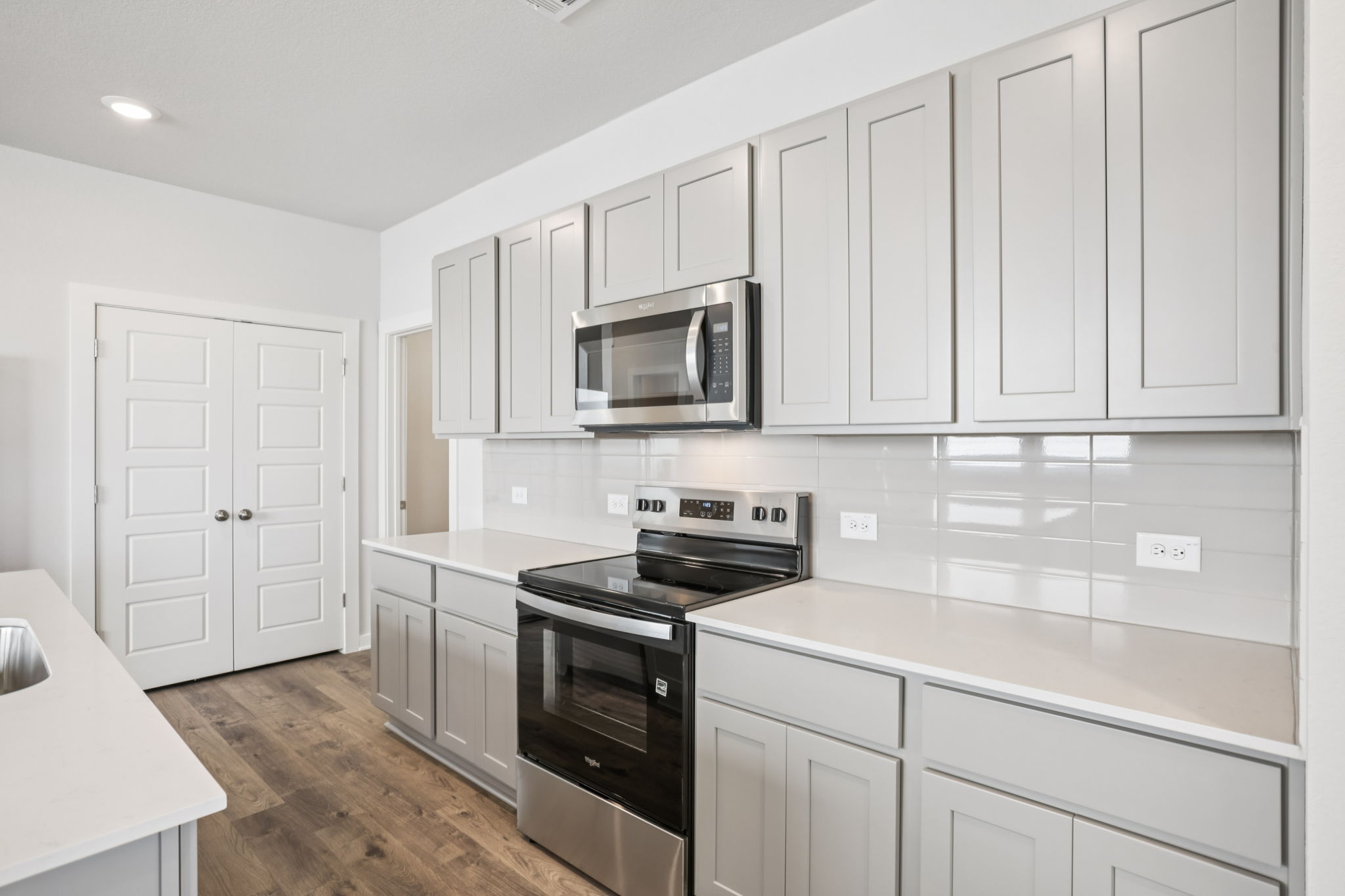 A kitchen with white cabinets.