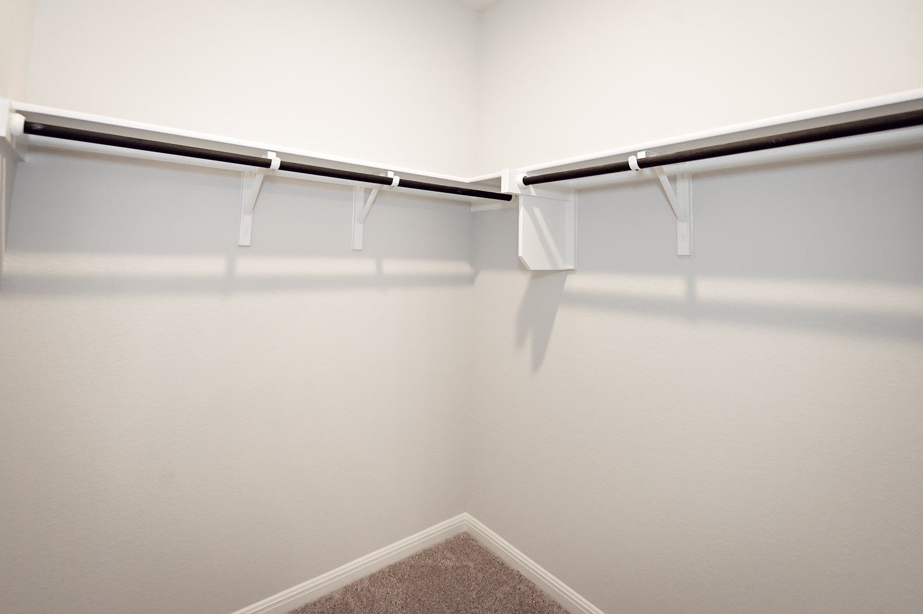 A white wall with a metal bar.