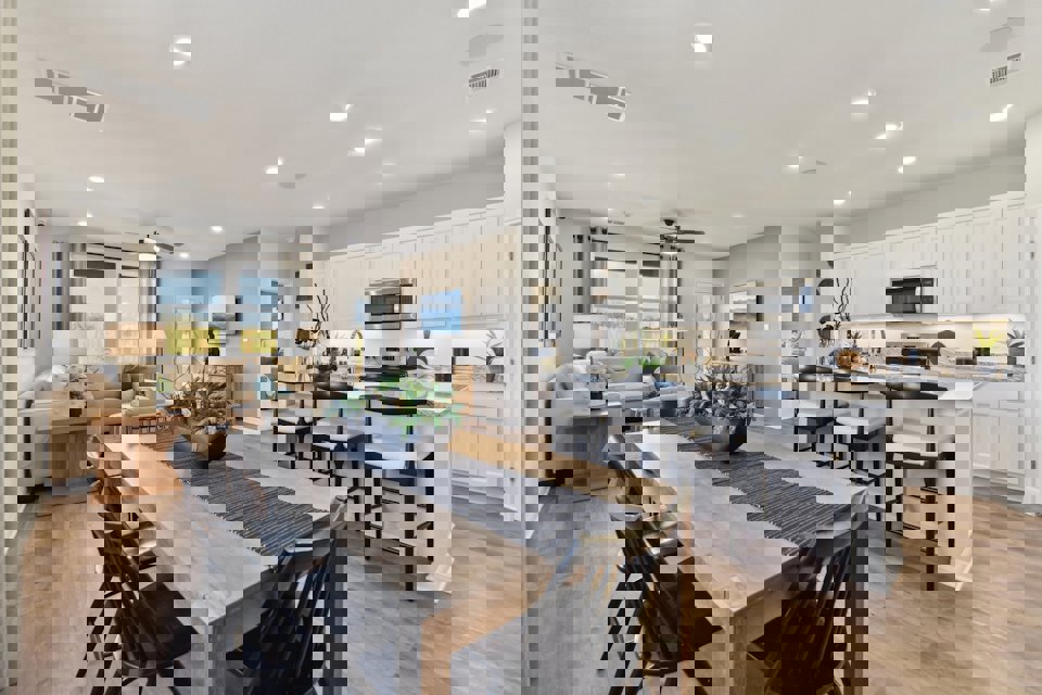 A kitchen with a dining table and chairs.