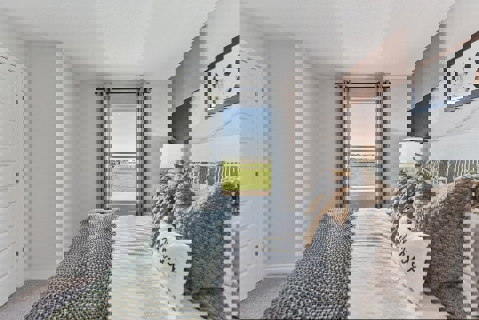 A bedroom with a large window.