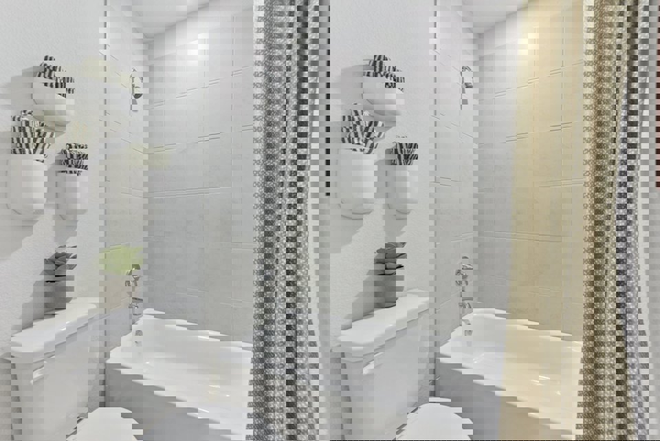 A bathroom with a tub toilet and sink.