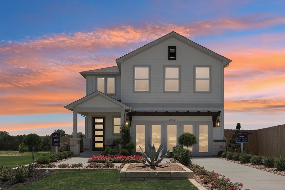 A house with a fountain in front of it.