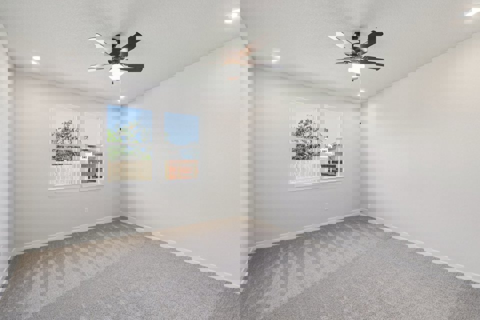 A room with a ceiling fan and a window.