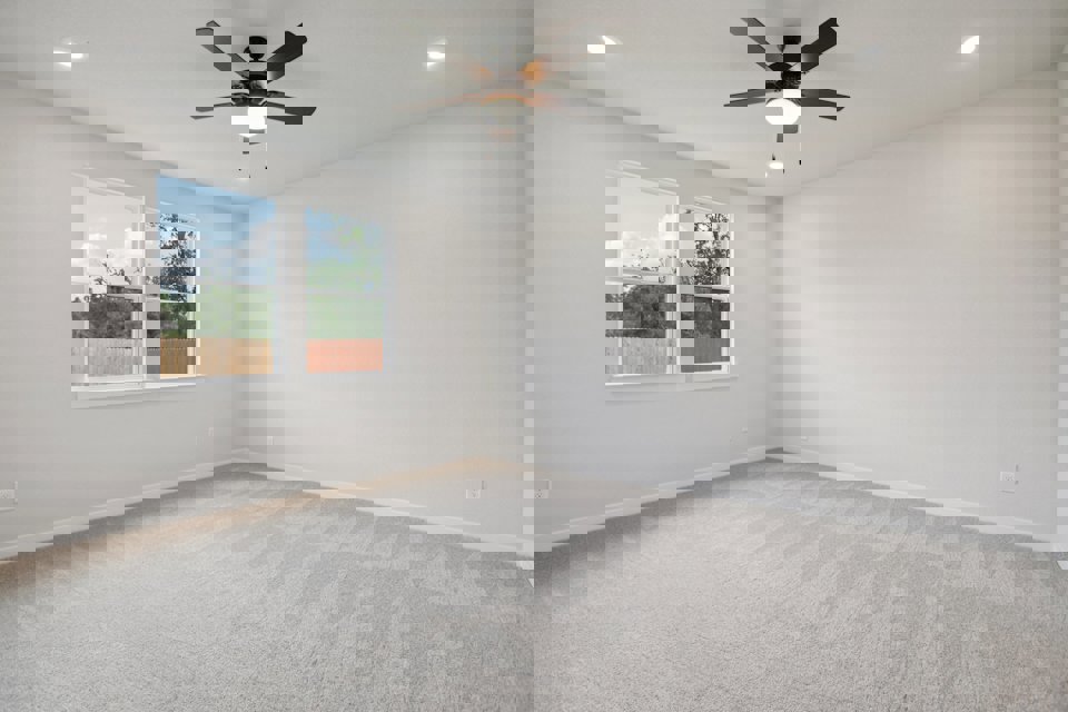 A room with a ceiling fan and a window.