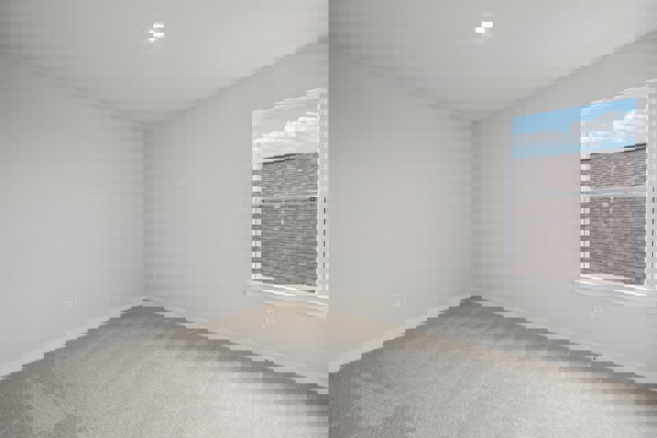 A room with a window and a white wall.