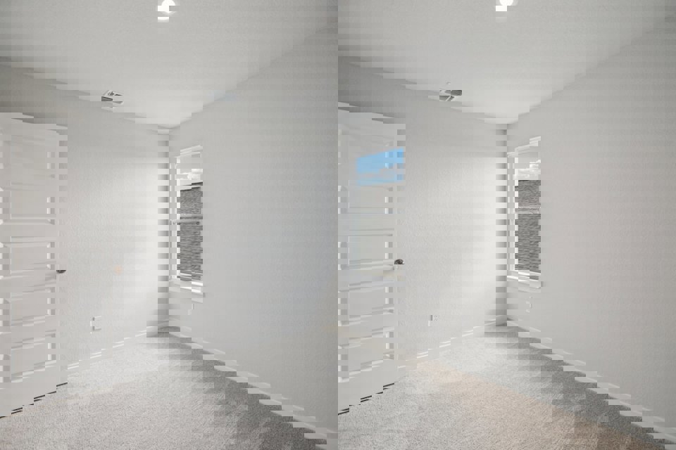 A room with white walls and a window.