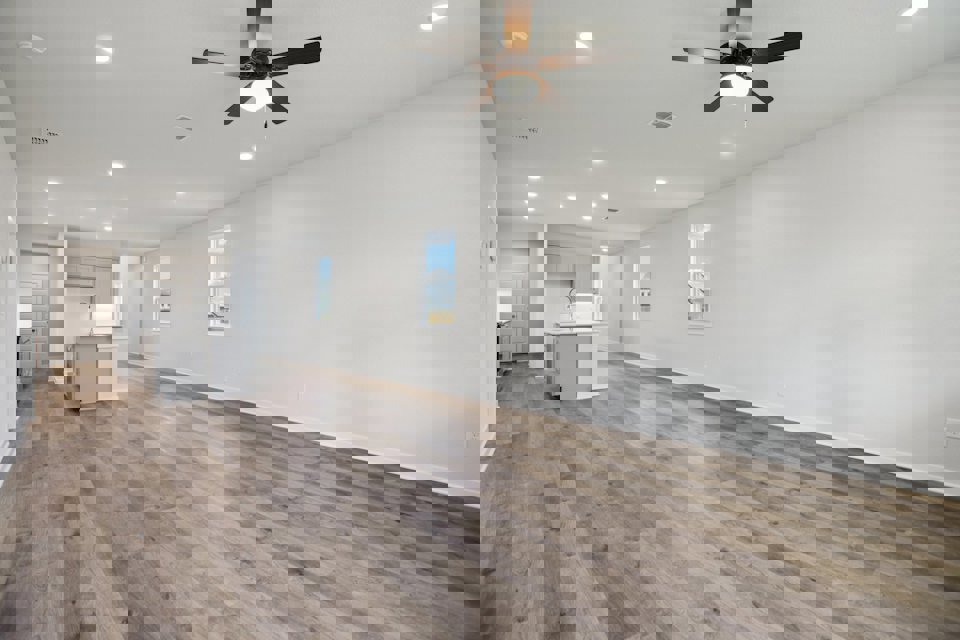 A room with a wood floor and a ceiling fan.