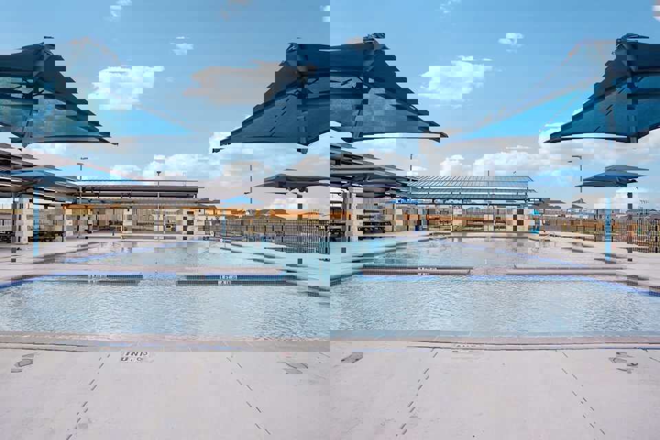 A pool with a building in the background.