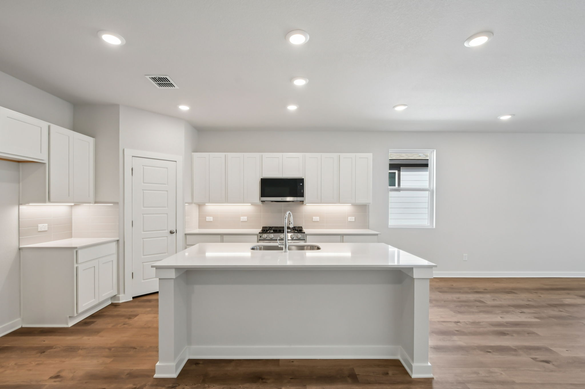 A kitchen with white cabinets.
