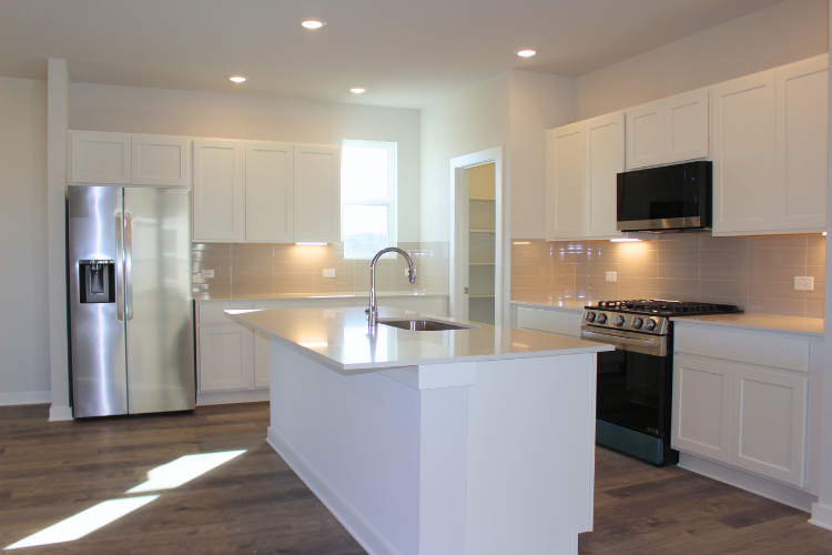 A kitchen with white cabinets.