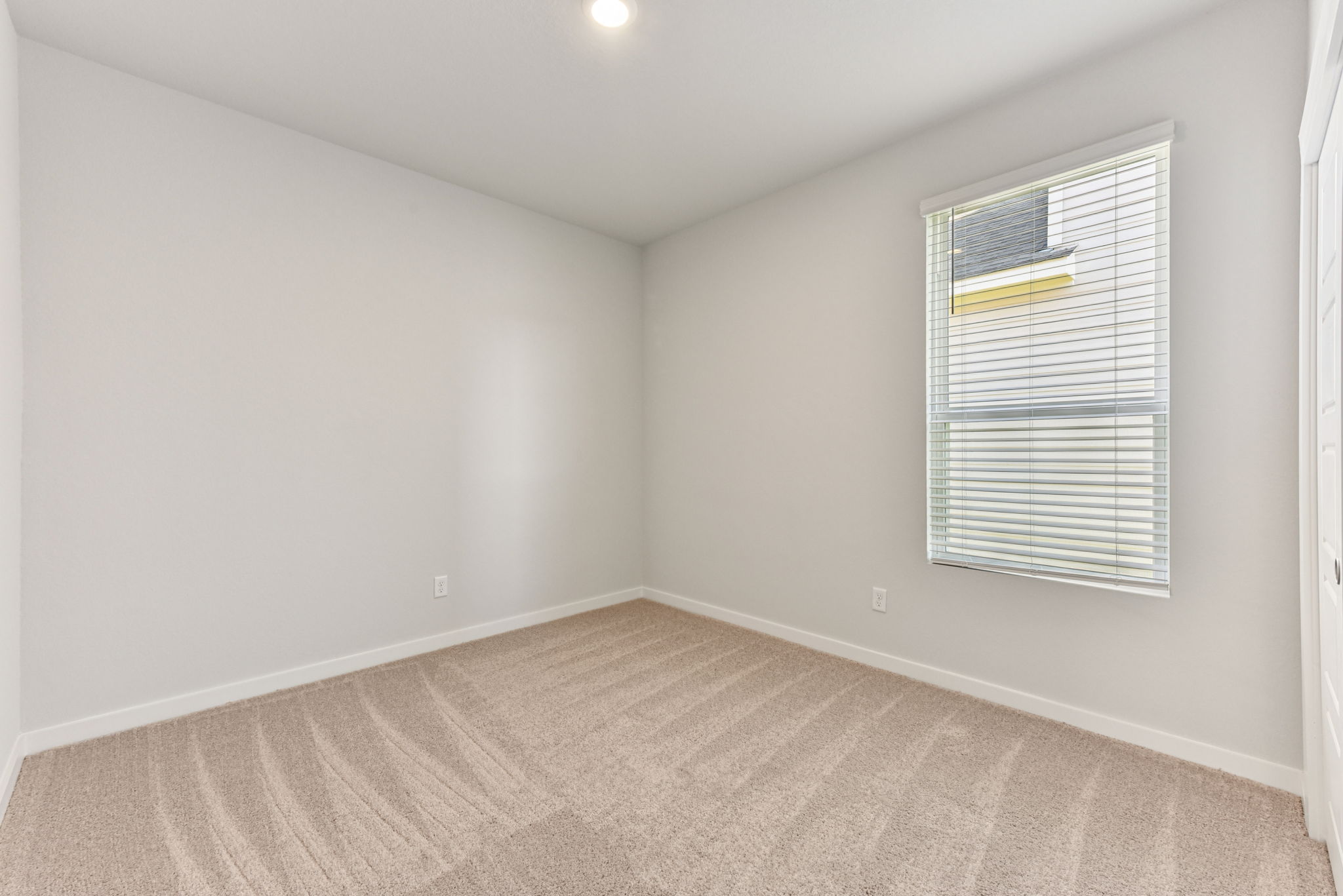 A room with a window and carpet.