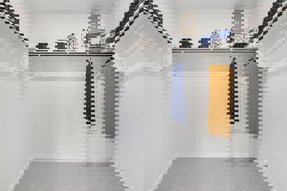 A white room with a shelf and a towel on the wall.