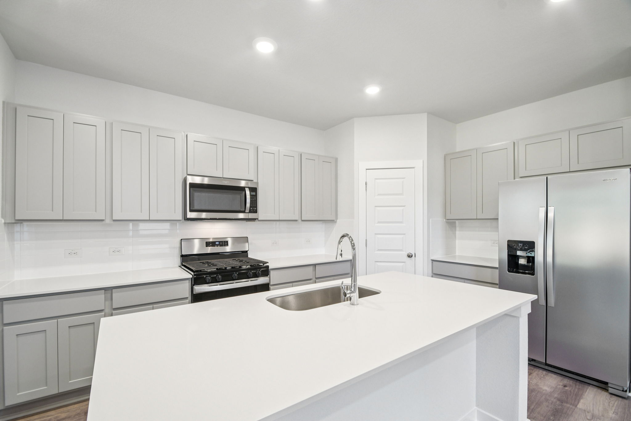 A kitchen with white cabinets.